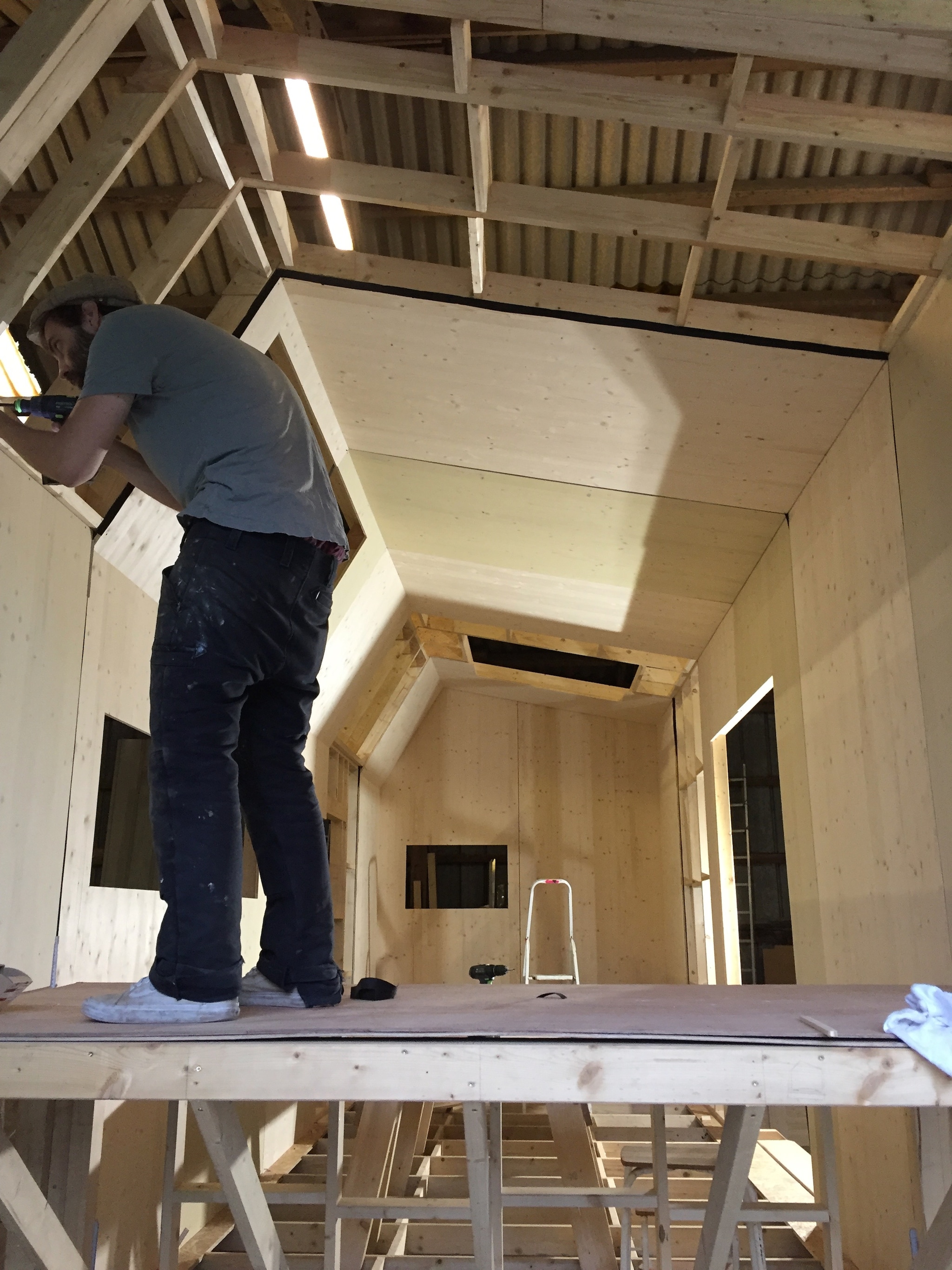 Schreiner verkleidet Innenwand im Tiny House